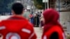 FILE - Members of the Syrian Red Cross stand near aid vehicles in the besieged town of Madaya about 15 miles (24 kilometers) northwest of Damascus, Syria, Jan. 11, 2016. Red Cross trucks were refused entry Thursday in the Syrian town of Daraya.