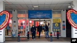 People leave the Charing Cross hospital in London, Friday, Jan. 8, 2021. Britain’s National Health Service will from next week employ a little-used field hospital specially built at a huge exhibition center in east London in the early days of the…