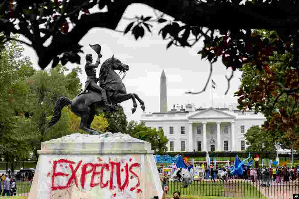 Pawol "Tann Nou" make an wouj nan pye statu Andrew Jackson nan pak Lafayette, nan moman kote militan endijen ak anvironmantalis ap pwoteste devan Mezon Blanch la, 11 Oct. 2021.