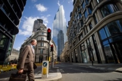 Un hombre cruza la calle durante la hora del almuerzo en la ciudad de Londres el 21 de agosto de 2020.