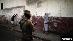 Foto de archivo un soldado salvadoreño observa a hombres detenidos durante un operativo militar como parte de las medidas de seguridad ordenadas por el presidente de El Salvador, Nayib Bukele, de mantener a las personas dentro de sus casas durante una cuarentena en todo el país.