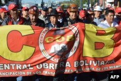 El presidente de Bolivia, Luis Arce (C-R) y su vicepresidente David Choquehuanca (C-L), participan en una marcha de la Unión de Trabajadores de Bolivia (COB) para conmemorar el Día Internacional del Trabajo en Cochabamba, Bolivia, el 1 de mayo de 2024.