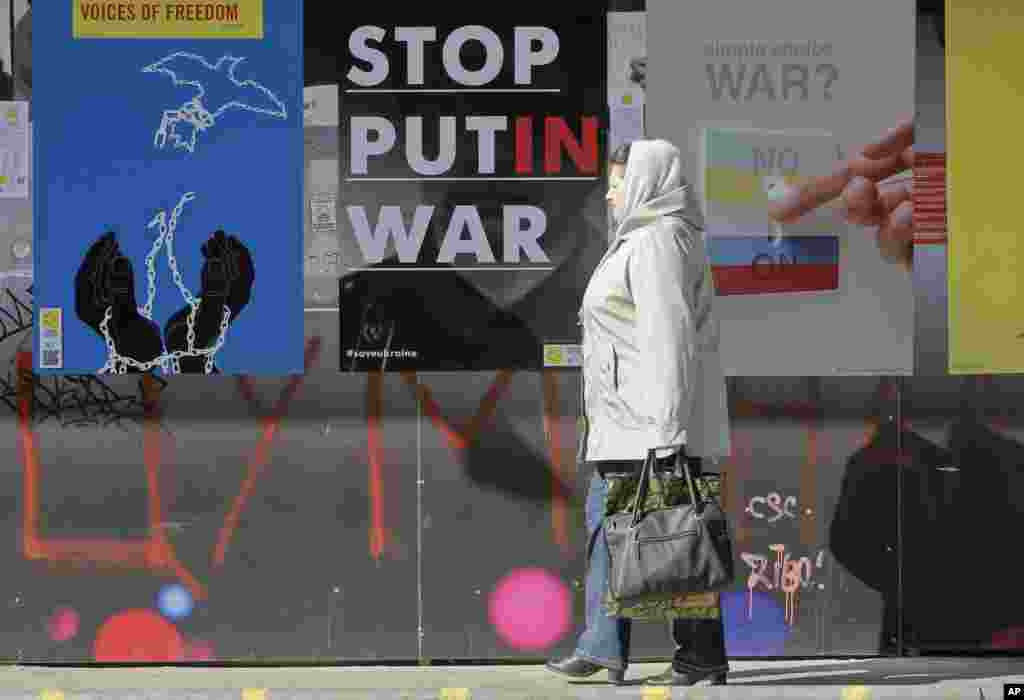 A woman passes by posters in support of Ukraine during the International poster campaign, Kyiv, March, 12, 2014.