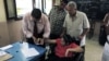 An Egyptian election worker helps a disabled woman in a wheelchair to vote at a polling station during the second day of the presidential runoff in Cairo, June 17, 2012.