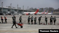 Soldados barren la pista del Aeropuerto Internacional La Aurora, que fue cerrado el 23 de marzo de 2021 por la caída de ceniza proveniente del volcán Pacaya. [Foto: Dirección General de la Aeronáutica Civil]