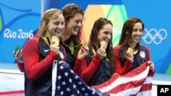 Tim perenang putri Amerika Serikat, dari kiri ke kanan, Katie Ledecky, Allison Schmitt, Leah Smith dan Maya DiRado, memegang medali emas mereka setelah memenangkan nomor estafet putri 4x200 meter dalam Olimpiade 2016 di Rio de Janeiro (11/8). (AP/Lee Jin-man)