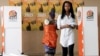 Voters prepare for casting their votes at a polling station as the country goes to the polls in Maputo, Mozambique, Oct. 15, 2014. 