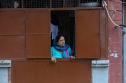 A Kashmiri Hindu woman looks from inside her residence at the Jagti migrant camp in Jammu, India, Aug. 23, 2019. Tens of thousands of Kashmiri Hindus fled the restive region nearly 30 years ago.