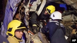 In this photo made available by the Oman Police, Omani civil defense workers rescue people from a damaged bus after a crash, near Nahdah area on the road connecting the cities of Fahud and Ibriin, in Oman, March 1, 2016.