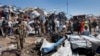 Somali soldiers walk through the wreckage after a car bomb that targeted a police station in the Waberi neighborhood, where President Hassan Sheikh Mohamud was visiting a university, in the capital Mogadishu, Somalia Saturday, Nov. 26, 2016.