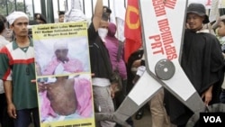 Sejumlah TKI memegang poster protes dalam demonstrasi di depan gedung DRP/MPR, terkait kasus penyiksaan Sumiati.