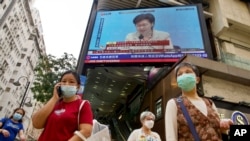 A TV broadcasts Hong Kong Chief Executive Carrie Lam during a news conference in Hong Kong, March 30, 2021, as China's top legislature approved amendments to Hong Kong's constitution giving Beijing more control over the makeup of the city's legislature.