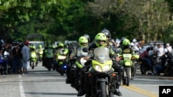 ARCHIVO - La policía escolta vehículos que viajan de Caucacia a Medellín, para ayudarlos a pasar con seguridad por Taraza, Colombia, el martes 14 de marzo de 2023.