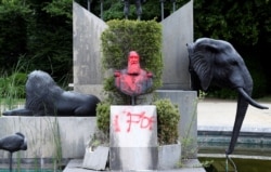 FILE - A statue of former Belgian King Leopold II has been vandalized, in the park of the Africa Museum, in Tervuren, near Brussels, Belgium, June 9, 2020.