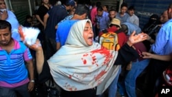 Seorang perempuan yang pakaiannya berlumuran darah menjerit saat terjadi bentrokan antara pasukan pemerintah dan pendukung presiden terguling Mohamed Morsi, Jumat (16/8)