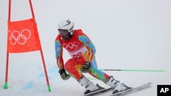 Shannon Abeda, de Eritrea, pasa una puerta durante la primera carrera de eslalon gigante masculino en los Juegos Olímpicos de Invierno de 2022, el domingo 13 de febrero de 2022, en el distrito de Yanqing de Beijing. 