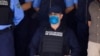 El expresidente hondureño Juan Orlando Hernández junto a oficiales de la policía luego de ser detenido por miembros de la Policía Nacional de Honduras, en Tegucigalpa, Honduras, el 15 de febrero de 2022.