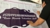 Seorang laki-laki membubuhkan pesan menolak perkawinan anak di atas spanduk yang dipajang dalam Festival Kabupaten/Kota Layak Anak (KLA) yang digelar di Bandung, Minggu (16/12/2018) siang. (Foto: Rio Tuasikal/VOA)