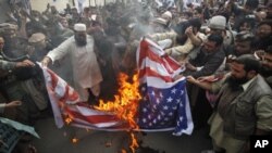 Supporters of religious parties burn a U.S flag during a protest against U.S. citizen Raymond Davis near the U.S consulate in Lahore February 18, 2011.