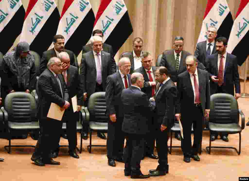 Members of the incoming Iraqi cabinet speak to one another during a parliamentary session to vote on Iraq's new government at the parliament headquarters in Baghdad, Sept. 8, 2014.