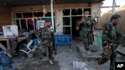 Afghan security forces inspect damages after clashes between Taliban fighters and Afghan forces in Kandahar Airfield, Afghanistan, Wednesday, Dec. 9, 2015.