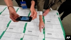 FILE - A canvas observer photographs Lehigh County provisional ballots during vote counting in Allentown, Pennsylvania, Nov. 6, 2020. 