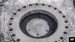 Esta fotografía proporcionada por la NASA el miércoles 11 de octubre de 2023 muestra la parte exterior del recolector de muestras Osiris-Rex con material del asteroide Bennu. 