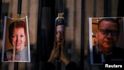 Una persona coloca fotos de periodistas asesinados durante una manifestación para protestar contra el asesinato de periodistas en los últimos días, frente al edificio de la Secretaría del Interior de México en la Ciudad de México, México, 14 de febrero de 2022.