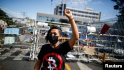 Una mujer con una camiseta de "No a Bitcoin" participa en una protesta contra el presidente de El Salvador, Nayib Bukele, en el Congreso Nacional en San Salvador, El Salvador, 9 de febrero de 2022. 