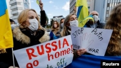 Ucranianos residentes en Japón sostienen pancartas y banderas durante una manifestación de protesta denunciando a Rusia por sus acciones en Ucrania, cerca de la embajada rusa en Tokio, Japón, el 23 de febrero de 2022.