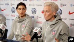 FILE - United States women's national soccer team member Alex Morgan, left, listens as teammate Megan Rapinoe speak to reporters during a news conference in New York, Friday, May 24, 2019.
