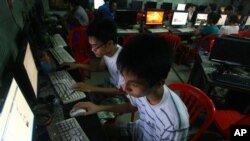 In this Sept. 27, 2012 photo, two Vietnamese students use Facebook at an Internet cafe near their dormitory while they could not log in Facebook from their mobile phones because of firewall in Hanoi, Vietnam. In Vietnam, new blogs, Facebook accounts and Twitter feeds are appearing everyday, attracting readers fed up with the state-controlled media and tales of corruption, police brutality and calls for freedom of expression.