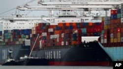 The Yang Ming shipping line container ship Ym Utmost is unloaded at the Port of Oakland, July 2, 2018, in Oakland, Calif. 