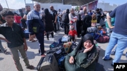 Palestinos, algunos con pasaportes extranjeros, tratan de cruzar hacia Egipto mientras otros esperan por ayuda en el cruce de Rafah, en el extremo sur de la Franja de Gaza, el 16 de octubre de 2023.