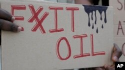 Una persona exhibe un cartel que demanda la salida de las empresas petroleras de la cumbre climática de la ONU COP28 en Dubái, el 4 de diciembre de 2023.