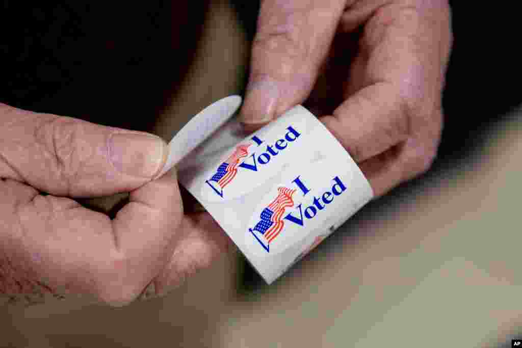 An election worker holds a roll of "I Voted" stickers in Manchester, N.H., Feb. 11, 2020.