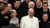 Pope Francis poses with a group of priests at the end his Wednesday general audience in Saint Peter's square at the Vatican Feb. 26, 2014.