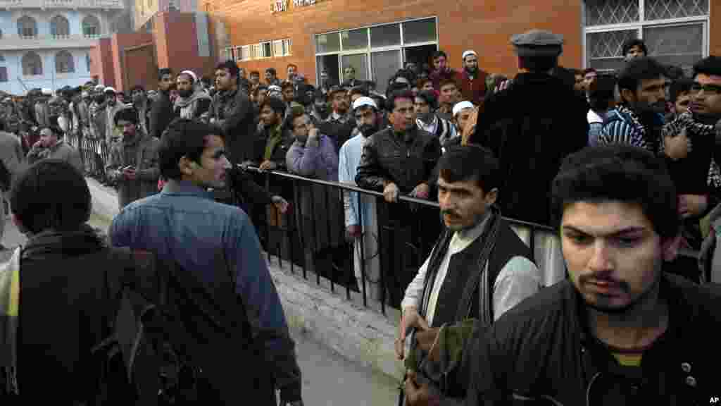 People gather at a hospital, where victims of a Taliban attack are being treated in Peshawar, Pakistan, Dec. 16, 2014.