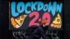 A man cycles past a mural on the boarded up window of a closed pizza restaurant amid the outbreak of the coronavirus disease in Manchester, Britain, Jan. 4, 2021. 