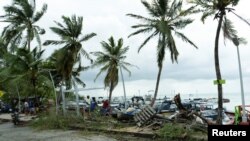 La gente mira los escombros y los barcos apilados después de que el huracán Julia pasa por la isla de San Andrés, Colombia, 9 de octubre de 2022.