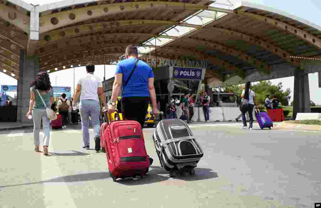 Passengers pull their bags as they arrive at Sabiha Gokcen Airport, in Istanbul, July 17, 2016. Rather than toppling the country's strongman president, a failed military coup appears to have bolstered Recep Tayyip Erdogan's immediate grip on power and boosted his popularity. 