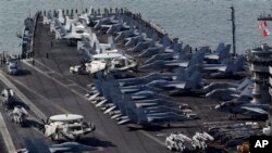 Awak kapal berdiri di dek kapal induk berkekuatan nuklir USS Nimitz di Busan, selatan Seoul (11/5). Korea Selatan-AS memuai latihan militer bersama mereka hari ini (13/5)..