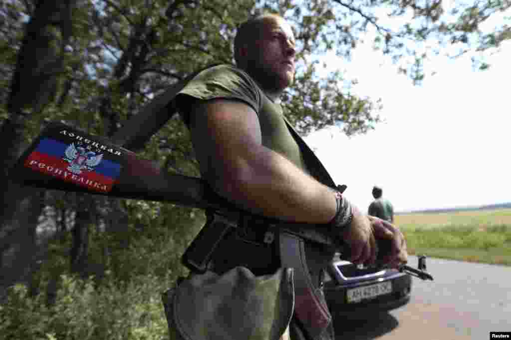 A pro-Russian separatist rebel guards a checkpoint near the village of Rozsypne in Ukraine's eastern Donetsk region August 4, 2014.