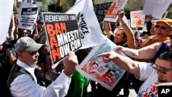 Pro dan kontra terkait imigrasi saat berlangsungnya Gerakan Puente menentang deportasi, pemisahan keluaraga dan kekerasan di tempat kerja di Phoenix, Arizona, 11 Maret 2013 (Foto: dok). Pengusaha dan karyawan AS telah menyepakati program pekerja tamu, yang melapangkan jalan menuju status kewarganegaraan bagi 11 juta imigran gelap di Amerika. 