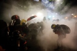 Agentes federales lanzan gas lacrimógeno a un grupo de manifestantes durante una protesta de Black Lives Matter en el tribunal Mark O. Hatfield de Portland, Oregón, el domingo 26 de julio de 2020.