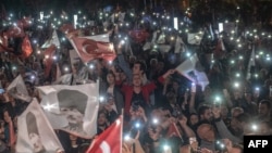 Supporters of Istanbul Mayor Ekrem Imamoglu wave flags as they take part in a protest against the re-run of the Istanbul mayoral election in Istanbul, May 6, 2019. 