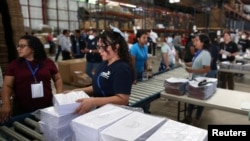 Trabajadores electorales organizan formularios de votación antes de las elecciones presidenciales en San Marcos, El Salvador, el 23 de enero de 2024.