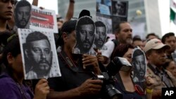 Para wartawan dan aktivis membawa foto wartawan Ruben Espinosa yang tewas dibunuh dalam aksi unjuk rasa di Mexico City, Minggu (2/8).