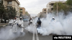 Members of firefighters wear protective face masks, amid fear of coronavirus disease (COVID-19), as they disinfect the streets, ahead of the Iranian New Year Nowruz, March 20, in Tehran, Iran March 18, 2020. Picture taken March 18, 2020. WANA (West…