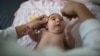FILE - A baby's head is measured by a neurologist at the Mestre Vitalino Hospital in Caruaru, Pernambuco state, Brazil, Dec. 22, 2015.
